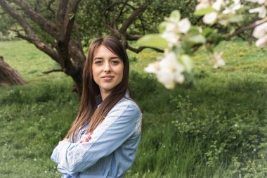 Bahar elma bahçesindeki güzel, genç bir kızın portresi.