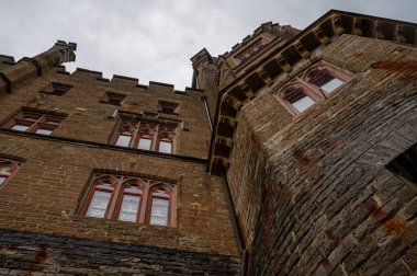 Almanya 'daki görkemli Hohenzollern Kalesi etkileyici ortaçağ mimarisi, yüksek kuleler ve çarpıcı bir gökyüzü altında karmaşık taş detaylar sergiliyor.