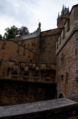 Kırsal taştan bir duvar, dar pencereler ve klasik bir fenerin yer aldığı bir ortaçağ Avrupa kale avlusunun mimari ayrıntıları. Tarihin, gücün ve fantezinin sembolü.