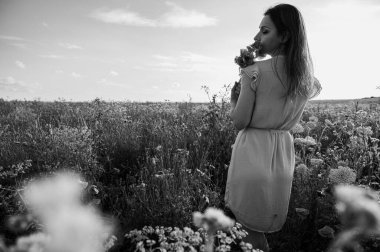 Çiçekler arasında mutlu bir kadının güzel siyah beyaz portresi. Monokrom tonu doğadaki bu dingin ve neşeli ana sonsuz, klasik bir his katar.