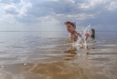 Mutlu çocuk gölde yüzüyor.