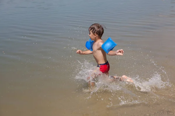 湖で泳いでいる幸せな少年 — ストック写真