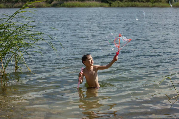 Kleiner Junge Pustet Seifenblasen Einem See — Stockfoto