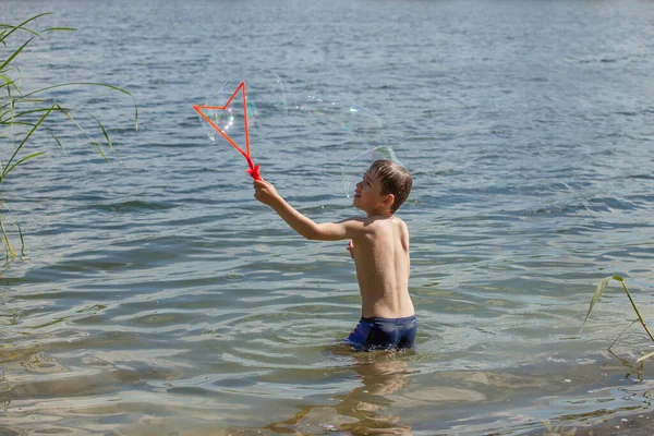 Malý Chlapec Fouká Mýdlové Bubliny Jezera — Stock fotografie