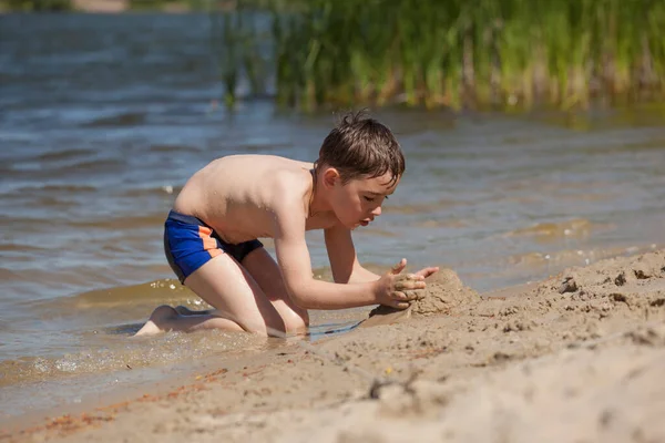 Mały Chłopiec Buduje Zamek Piasku Plaży — Zdjęcie stockowe