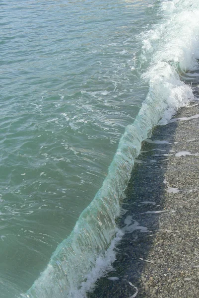 在阳光灿烂的日子里 海浪在海岸卵石上奔流 — 图库照片