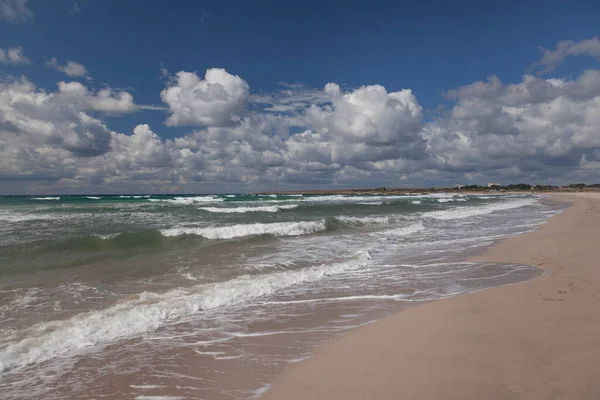 Seashore and clouds over the sea. Deserted sea beach