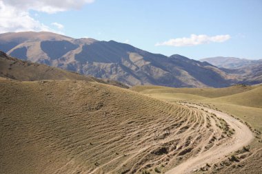 Dağların arasındaki toprak yol. Kazakistan