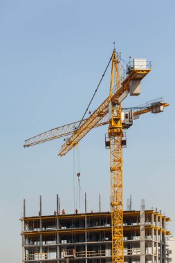 Mavi gökyüzüne karşı vinçleri olan inşaat alanı