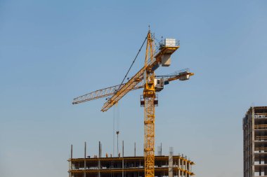 Mavi gökyüzüne karşı vinçleri olan inşaat alanı