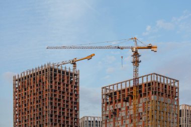 Mavi gökyüzüne karşı vinçleri olan inşaat alanı