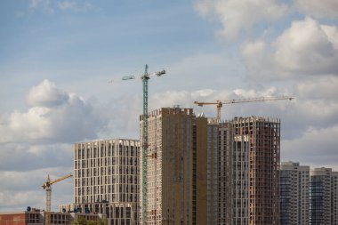 Mavi gökyüzüne karşı vinçleri olan inşaat alanı