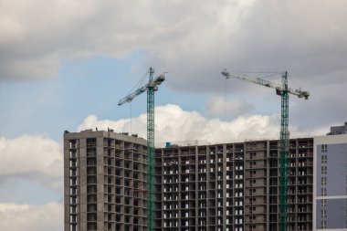 Gökgürültüsü bulutlarının arka planında kule vinci olan inşaat alanı