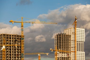 Gökgürültüsü bulutlarının arka planına karşı kule vinçleri olan inşaat alanı