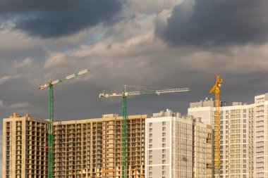 Gökgürültüsü bulutlarının arka planına karşı kule vinçleri olan inşaat alanı