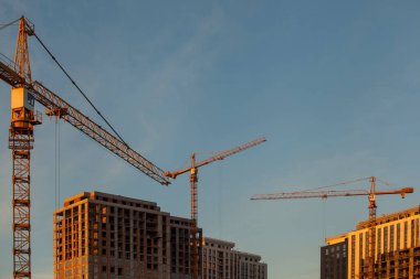 Mavi gökyüzüne karşı vinçleri olan inşaat alanı