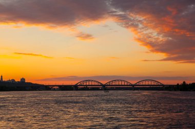 Gün batımında nehir manzarası. Parlak akşam bulutları
