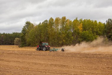 Traktördeki çiftçi gelecek yıl için fidelerle tarım arazisi hazırlıyor.