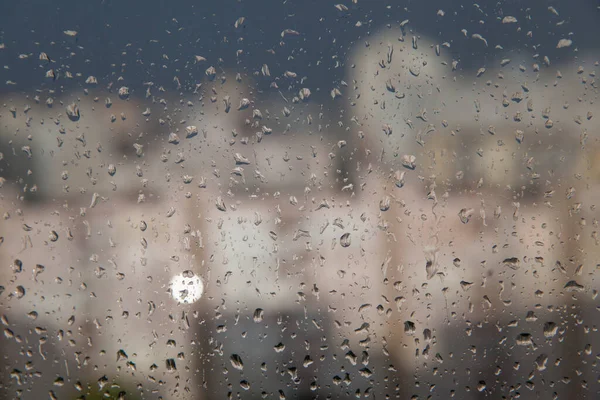 Regentropfen Auf Eine Fensterscheibe Vor Einem Hintergrund Städtischer Gebäude — Stockfoto