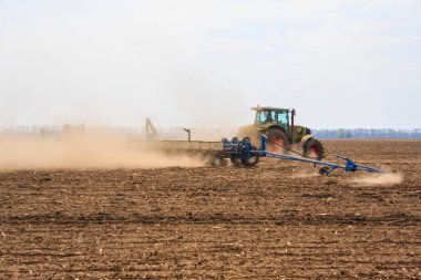 Traktördeki çiftçi gelecek yıl için fidelerle tarım arazisi hazırlıyor.