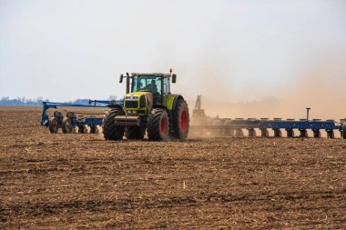 Traktördeki çiftçi gelecek yıl için fidelerle tarım arazisi hazırlıyor.