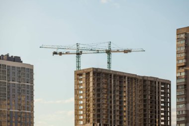 Mavi gökyüzüne karşı vinçleri olan inşaat alanı