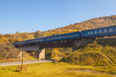 Dağlarda hareket eden bir yolcu treniyle sonbahar manzarası. Karpatlar. Ukrayna