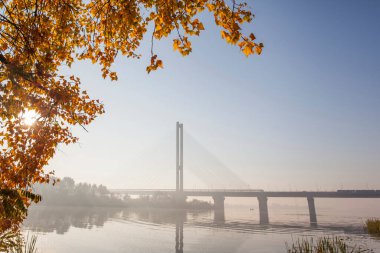 Sonbahar sabahları doğmakta olan güneşin zemininde köprü oluşturan bir manzara. Kiev 'deki güney köprüsü