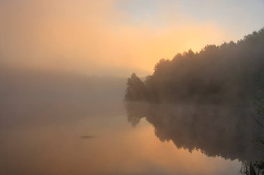 Sonbahar manzarası - sisle kaplı bir gölün üzerinde gün doğumu