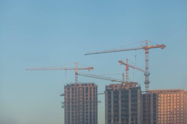Mavi gökyüzüne karşı vinçleri olan inşaat alanı