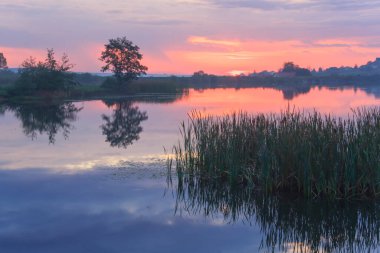 Gölün üzerinde gün doğumu. Sisli şafak