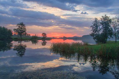 Gölün üzerinde gün doğumu. Sisli şafak