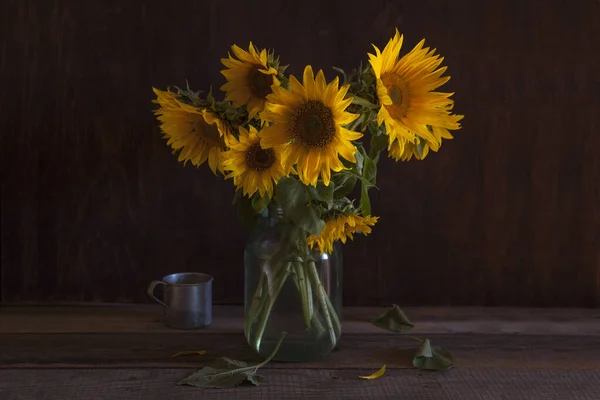 Bouquet of sunflowers in a glass vase on a dark background