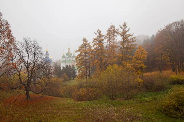 Orthodox church is sunlit in the middle of autumn park