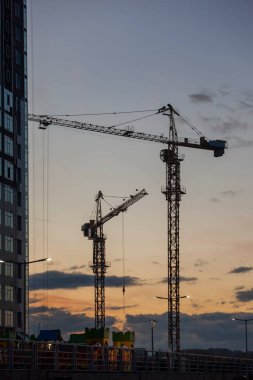 Gece bulutlarının arka planına karşı kule vinçleri olan inşaat alanı