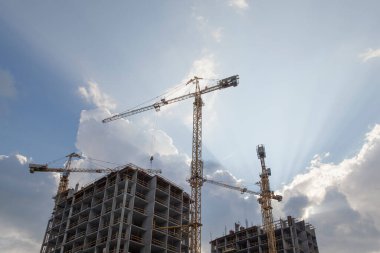 Gökyüzünün arka planında vinçler olan inşaat alanı
