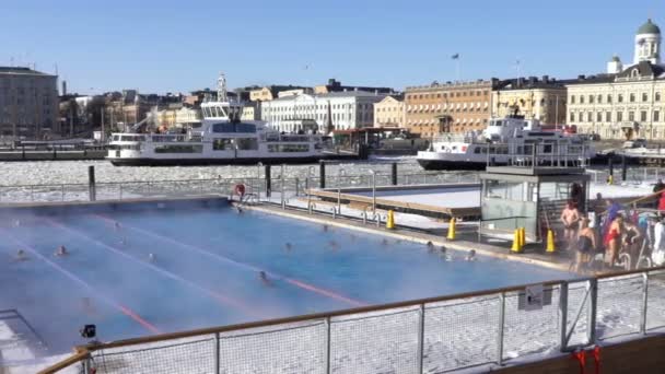 人々 は冬のヘルシンキ中心部の屋外海水プールで泳ぐ. — ストック動画