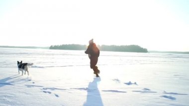 Genç kadın ile dondurulmuş deniz, göl buz üzerinde çalışan köpek