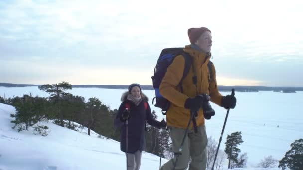 Fiatalok a téli kirándulás séta a snow backpackers-hegység — Stock videók