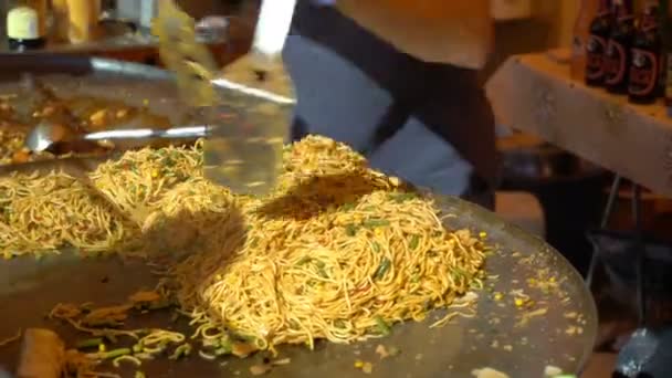 Los vendedores ambulantes preparan fideos asiáticos rápidos en la calle . — Vídeo de stock