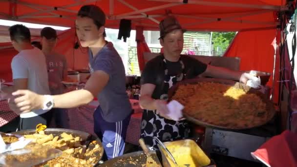 Молодые люди готовят фаст-азиатскую еду на улице . — стоковое видео