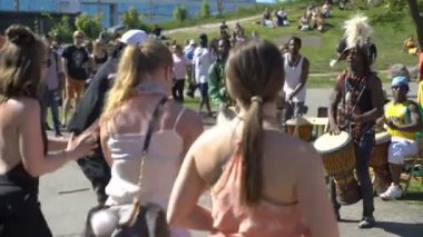 Afrika ve yerli Genç yerliler dans ve geleneksel millet Helsinki şehir parkında davul çalmak.