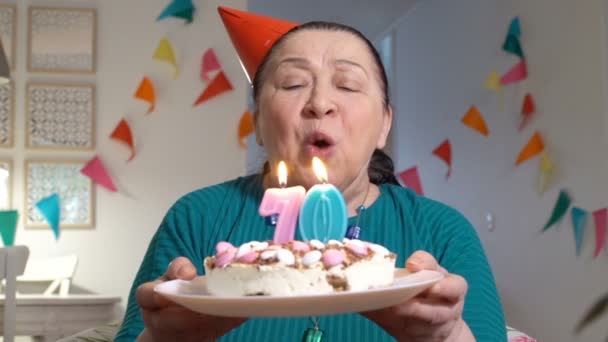 Feliz anciana sosteniendo pastel a la cámara mientras celebra cumpleaños con su familia a través de chat de vídeo — Vídeos de Stock