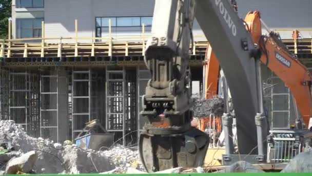 Tunga entreprenadmaskiner som arbetar på byggandet av ett nytt bostadsområde. — Stockvideo