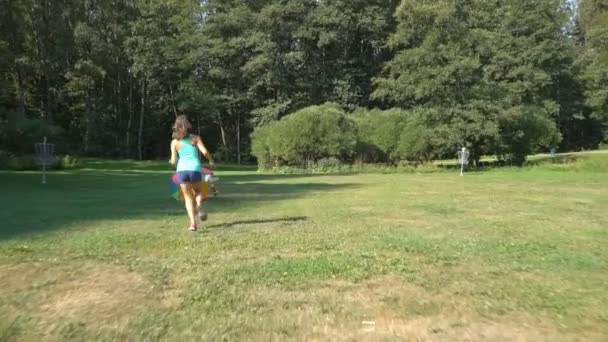 Dos chicas lindas de diferentes edades juegan con una gran bola inflable de arco iris colorido . — Vídeos de Stock