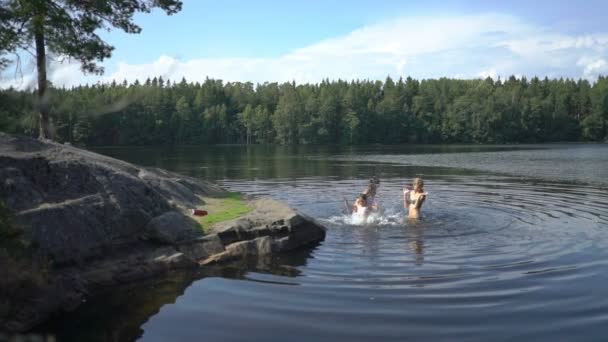 Familie zwemmen in het meer van een bos in Finland — Stockvideo