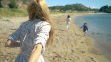 Genç kadını kocası doğru kayalık Kuzey Plajı yürüme giden çocuklu