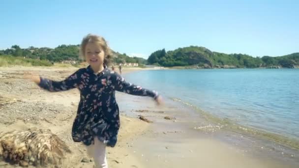 Kleines Mädchen läuft an einem sonnigen Sommertag an einem einsamen Nordstrand entlang. — Stockvideo