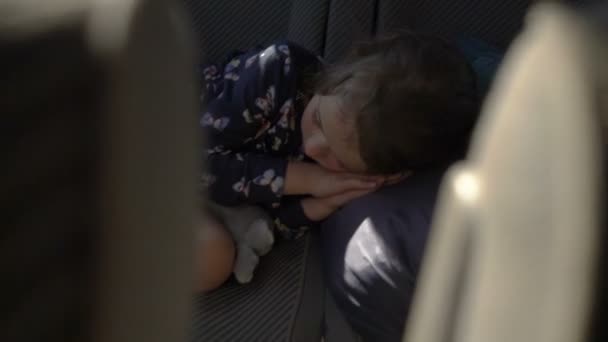 El niño durmiendo en el asiento trasero del coche . — Vídeo de stock