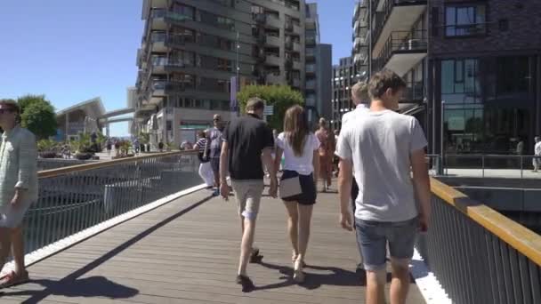 Mucha gente caminando en el paseo marítimo Aker Brygge en Oslo, Noruega . — Vídeos de Stock